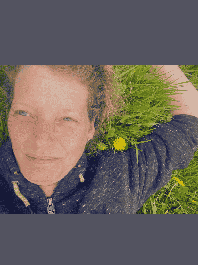Foto van Eunice Persoon ligt op het gras, in verbinding met de aarde - thema event Aarde